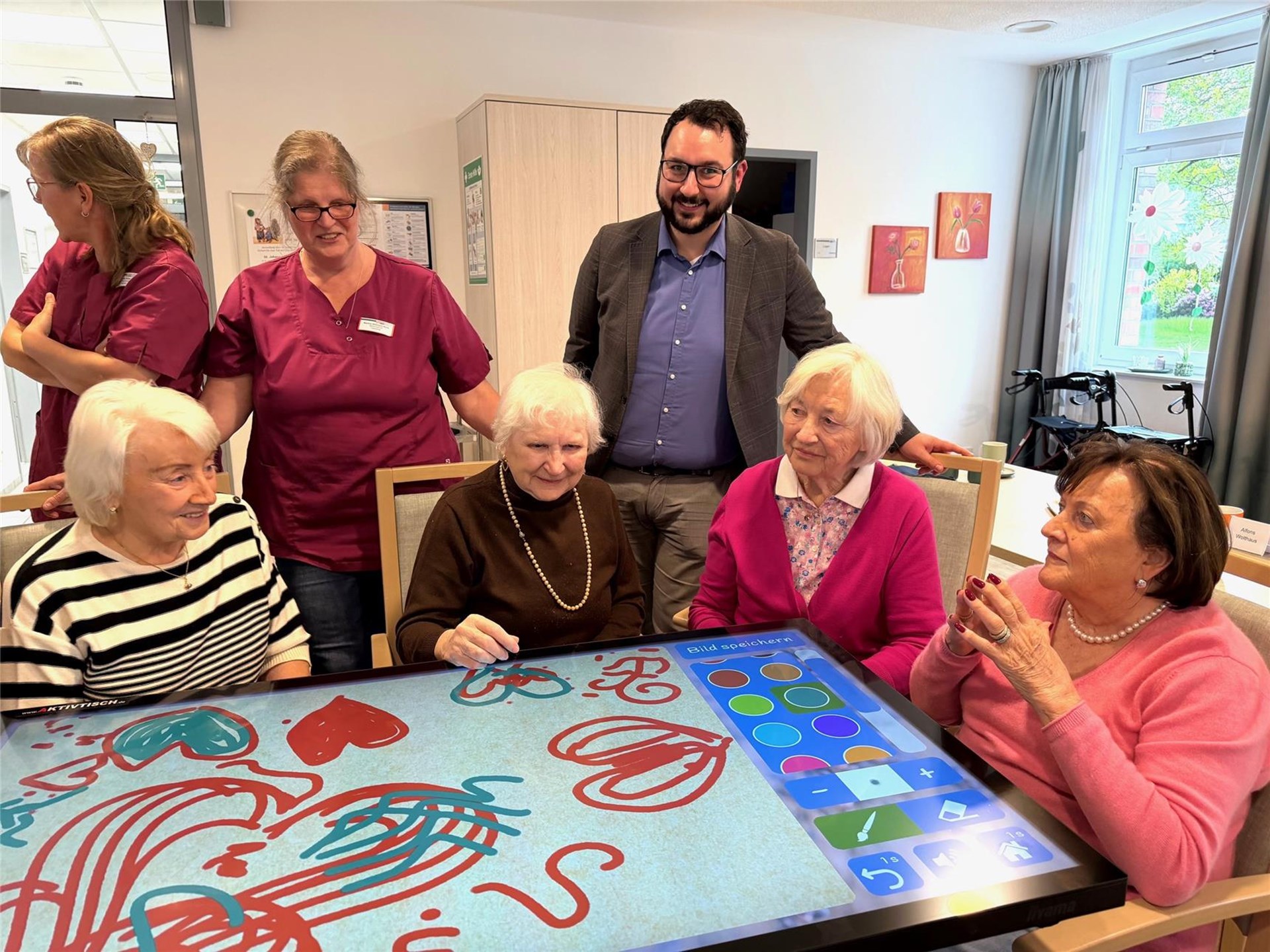 Philipp Althoff, Filialleiter der Sparkasse Bottrop-Kirchhellen, hat das Geschenk direkt mit ausprobiert und war ebenfalls ganz begeistert. Im Kreise von Seniorinnen am Aktivtisch
