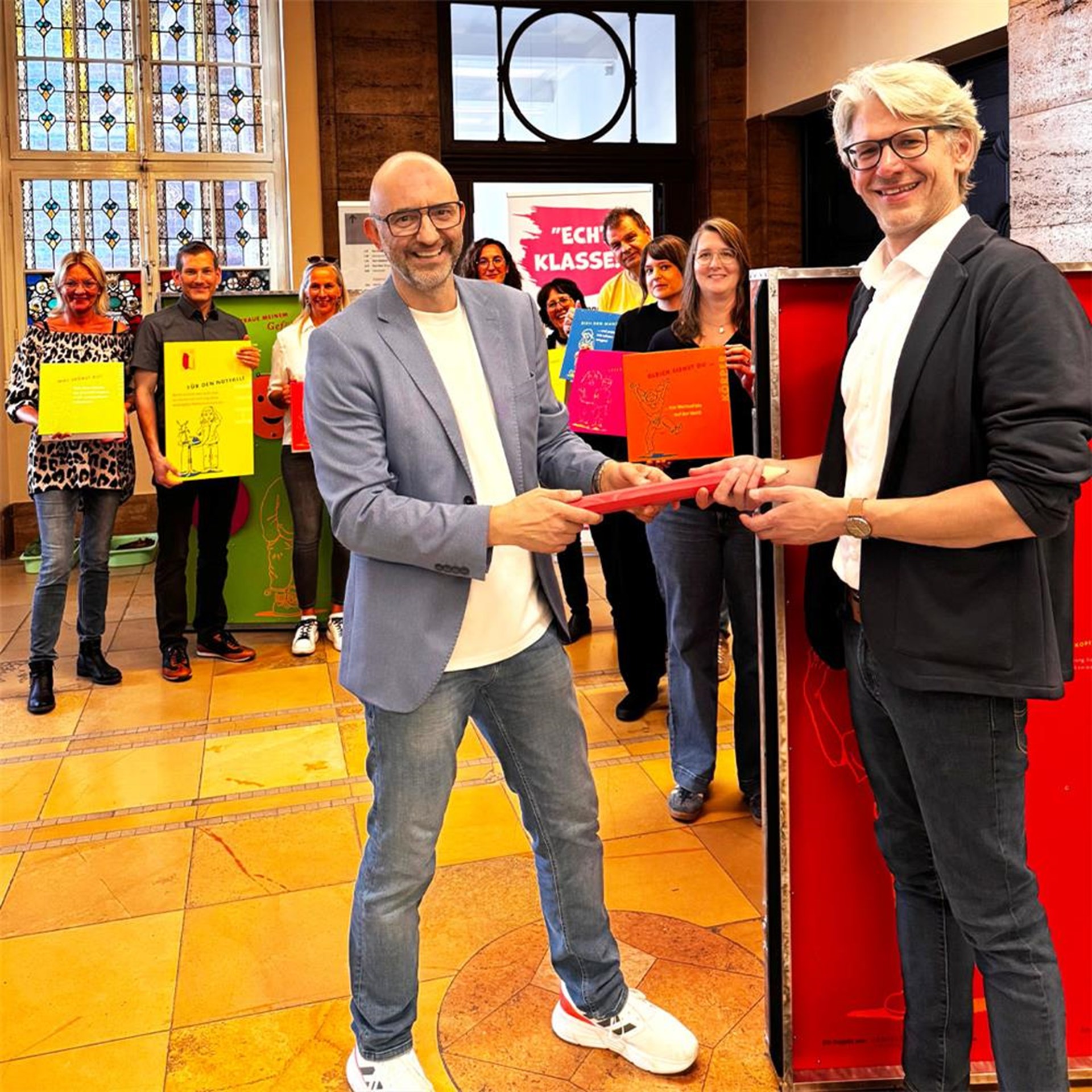 Jerome Braun übergibt das Projekt symbolisch an Alexander Hohler, Vorstand Caritasverband Bottrop, und Kooperationspartner