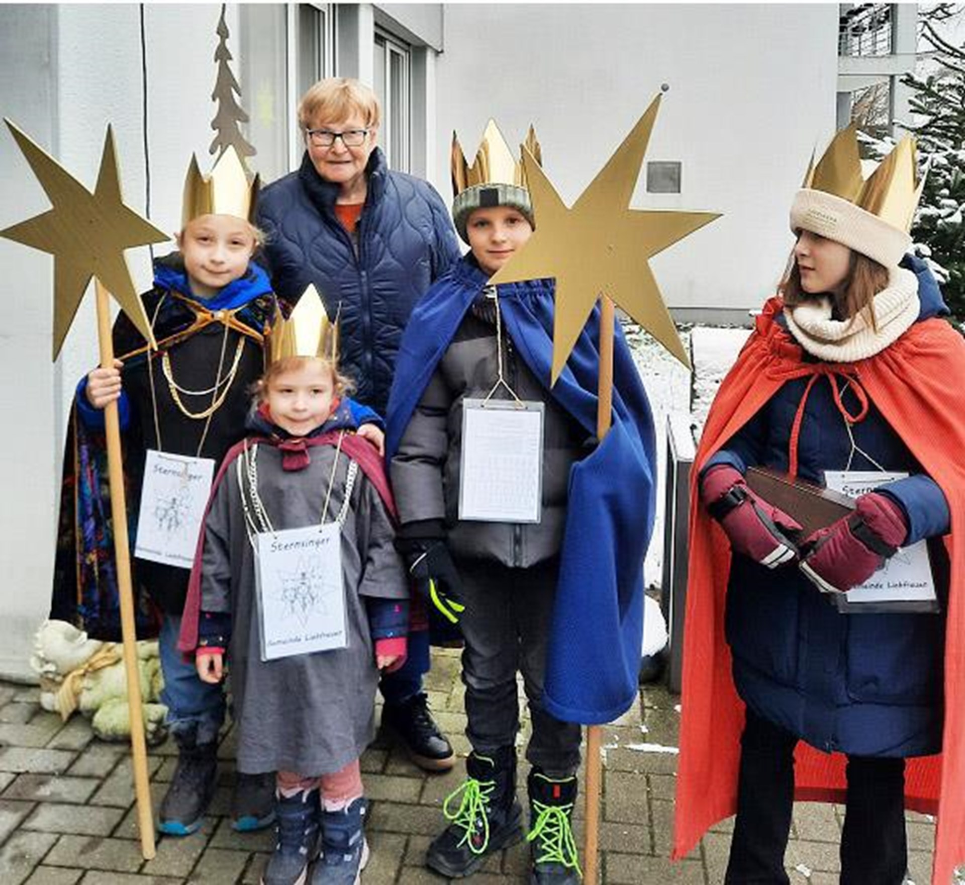 Eine kleine Gruppe Sternensinger in Gewändern vor der Senioreneinrichtung St. Hedwig