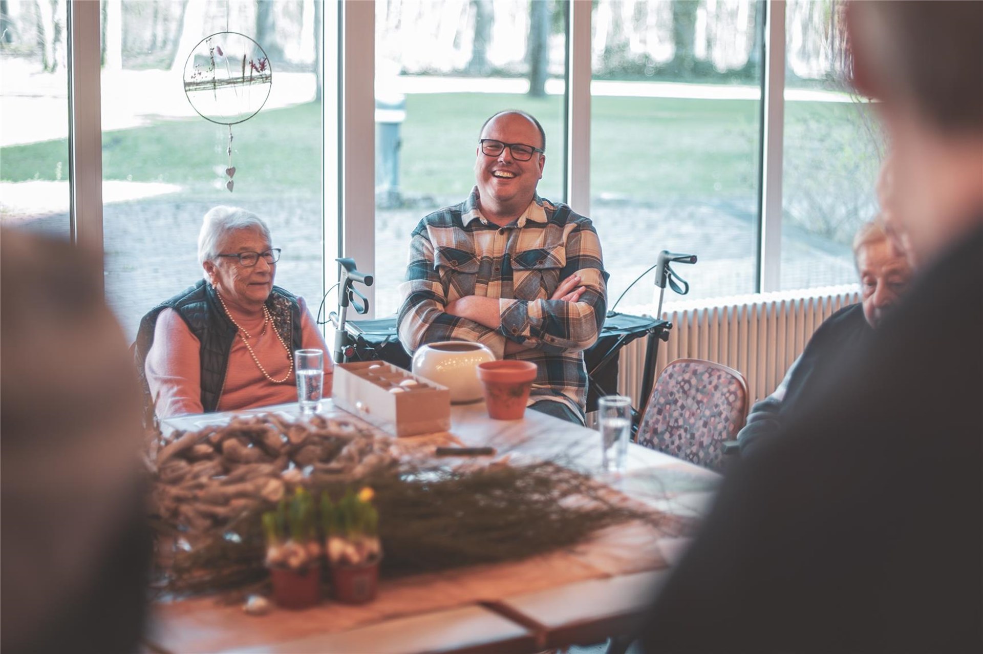 Lachende Besucher beim Basteln am Tisch